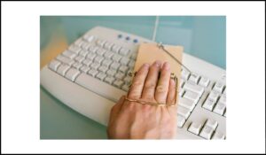 Mano atrapada en una trampa para ratones sobre un teclado de computadora, simbolizando la dificultad de escapar de un bloqueo de teclado en contenido web.