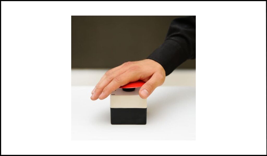 Mano presionando un botón rojo, representando la activación inmediata de un control sin opción de cancelación, un error de accesibilidad según WCAG 2.1.