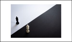 Dos piezas de ajedrez, una blanca sobre fondo negro y una negra sobre fondo blanco, simbolizando el contraste entre colores de primer plano y fondo en accesibilidad web.