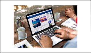 Persona navegando en un sitio web de noticias en su portátil, representando la importancia de evitar actualizaciones automáticas del contenido principal sin control del usuario.