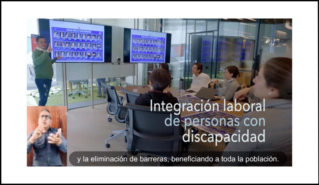 Sesión de integración laboral para personas con discapacidad en una sala de reuniones, con interpretación en lengua de señas y subtítulos en pantalla.