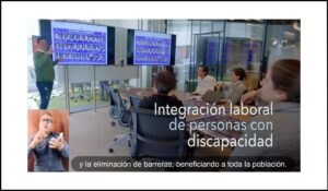 Sesión de integración laboral para personas con discapacidad en una sala de reuniones, con interpretación en lengua de señas y subtítulos en pantalla.