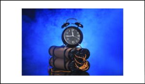 Reloj de alarma sobre un conjunto de dinamita con cables expuestos, simbolizando la presión del tiempo en actividades con límite, destacando la importancia de eliminar restricciones temporales para mejorar la accesibilidad.